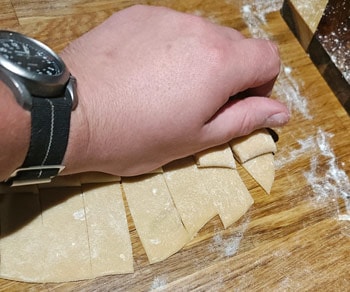 Picking up sliced homemade pasta
